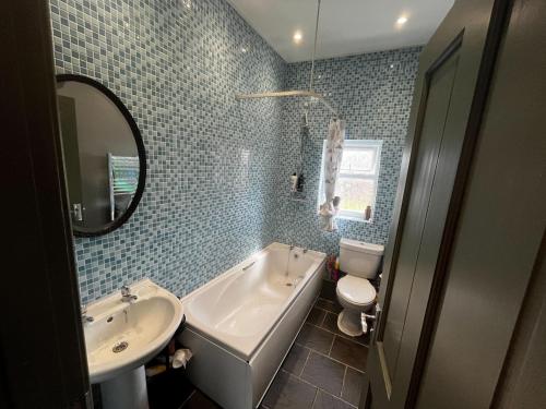a bathroom with a tub and a sink and a toilet at Cosy 2BR House Close to Burton-on-Trent Centre in Burton upon Trent