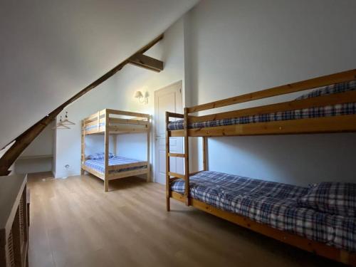 a bedroom with two bunk beds and a staircase at Gîte 11 personnes en pleine campagne in Sainte-Anne-sur-Vilaine