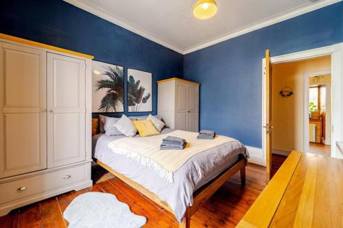 um quarto com uma cama grande e paredes azuis em Spacious 1-Bed City Centre Apartment in Aberdeen em Aberdeen