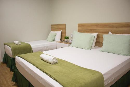 2 camas en una habitación con verde y blanco en Pureza Hotel, en Timon