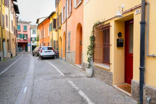 an alley with yellow and orange buildings and a car at bilocale centro storico Cesena Casa Ludo in Cesena