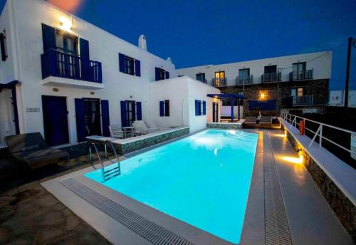 a large swimming pool in front of a house at Mykonos Pro-care Suites in Ano Mera