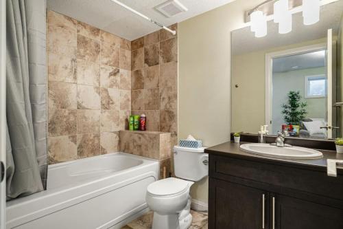 La salle de bains est pourvue d'une baignoire, de toilettes et d'un lavabo. dans l'établissement Large Modern style home with 5 Bedrooms Sleeps 12, à Edmonton