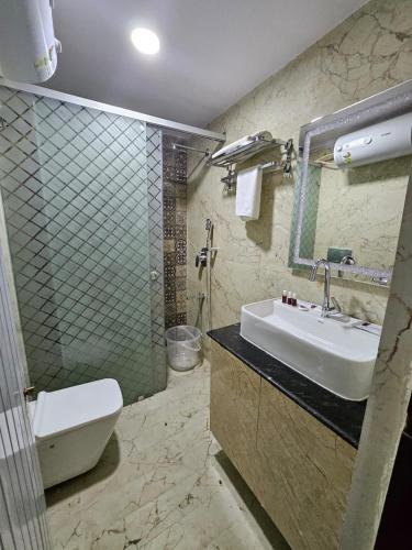 La salle de bains est pourvue d'un lavabo, de toilettes et d'une douche. dans l'établissement SS LUMINA GUEST HOUSE, à Bangalore