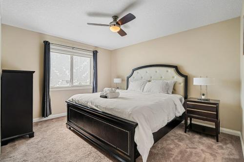 um quarto com uma cama grande e uma ventoinha de tecto em Large Modern style home with 5 Bedrooms Sleeps 12 em Edmonton