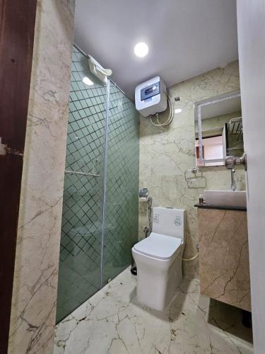 a bathroom with a toilet and a shower and a sink at SS LUMINA GUEST HOUSE in Bangalore