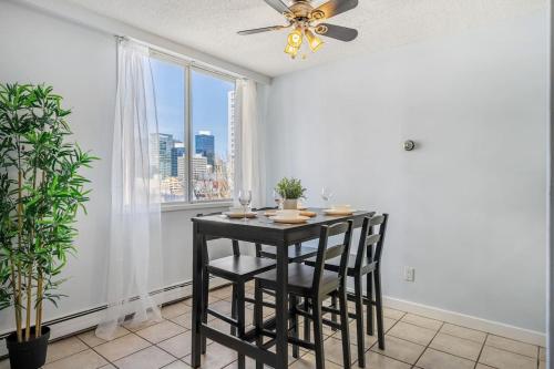 a dining room with a table and chairs and a window at Prime Location Near Jasper Ave with Downtown Views, Netflix, Gym, Sauna, Sleeps 4 in Edmonton