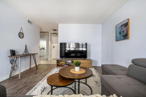 a living room with a couch and a table at Prime Location Near Jasper Ave with Downtown Views, Netflix, Gym, Sauna, Sleeps 4 in Edmonton