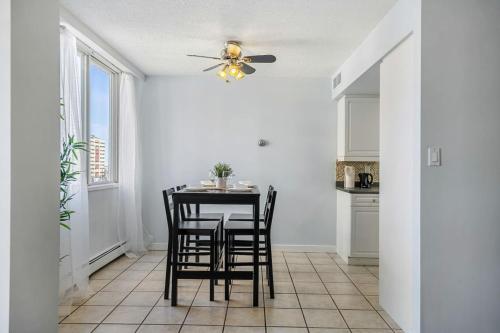 a kitchen with a table with chairs and a ceiling fan at Prime Location Near Jasper Ave with Downtown Views, Netflix, Gym, Sauna, Sleeps 4 in Edmonton