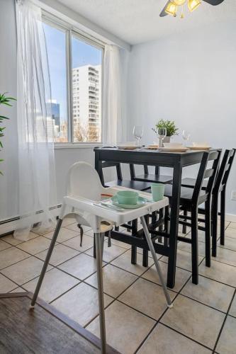 a dining room with a table and chairs and a window at Prime Location Near Jasper Ave with Downtown Views, Netflix, Gym, Sauna, Sleeps 4 in Edmonton