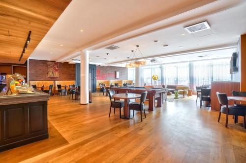 a restaurant with wooden floors and tables and chairs at Kyriad - Créteil - Bonneuil-sur-Marne in Bonneuil-sur-Marne