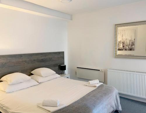 una camera bianca con un grande letto con due cuscini di Bed & Bike Zagreb studio apartment a Zagabria