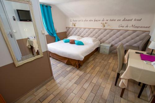 a small bedroom with a bed and a mirror at Hotel Chalet De L'isere in Cannes