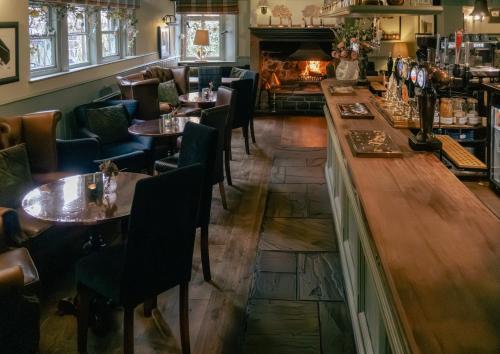a restaurant with tables and chairs and a fireplace at White Lion in Hebden Bridge