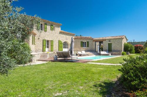 une maison en pierre avec une piscine et une cour dans l'établissement La Bastide Des As, à Gordes
