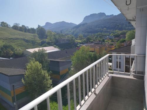 un balcón de una casa con montañas en el fondo en Los Tilos, en Ramales de la Victoria