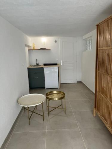 une cuisine avec une table, une table et un tabouret dans l'établissement Studio face à l'océan-Hourtin Plage, à Hourtin