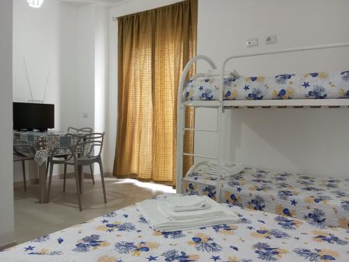 a bedroom with a bunk bed and a dining table at Palazzo Lembo in Agnone