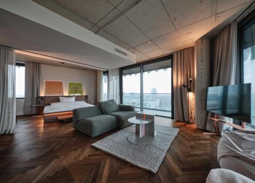 a living room with a couch and a bed and a television at The Zipper Hotel und Apartments in Düsseldorf