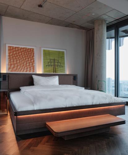 a bedroom with a large bed and a large window at The Zipper Hotel und Apartments in Düsseldorf