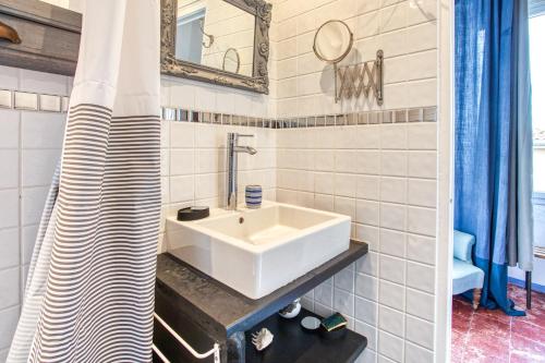 un bagno bianco con lavandino e specchio di Casa Di u Mare - Appt vue montagne a LʼÎle-Rousse