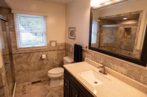 ein Badezimmer mit einem Waschbecken, einem WC und einem Spiegel in der Unterkunft Lakefront Haven Home in Monticello