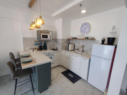 a kitchen with a white refrigerator and a sink at סוויטת פאר מול הים in Ashdod