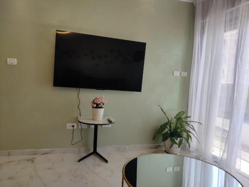 a living room with a flat screen tv on the wall at סוויטת פאר מול הים in Ashdod