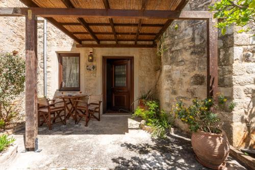 a patio with a table and chairs and a wooden ceiling at Kalimera Archanes Village in Archanes