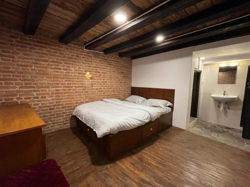 a bedroom with a bed in a brick wall at NEWA:INN in Kathmandu