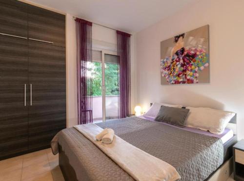 1 dormitorio con 1 cama y una pintura en la pared en M & B, en Bibinje