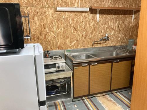 una piccola cucina con lavandino e frigorifero di 田舎の別荘 かすみ草 a Shōgahora
