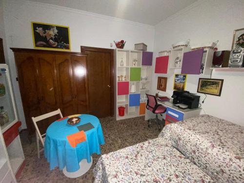 a bedroom with two beds and a table and a desk at Alojamiento Ruizo in Lorca