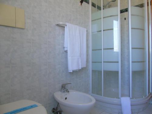 a bathroom with a shower and a toilet and a sink at Homiday - Villino Caroli in Pineto