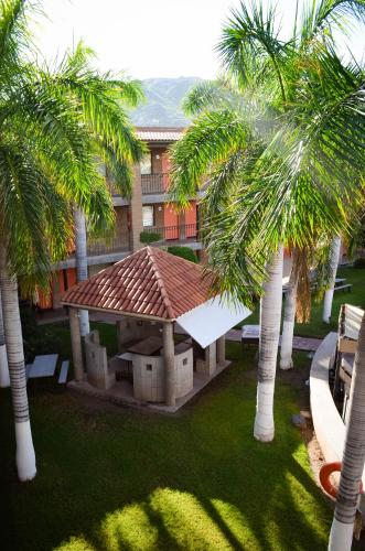 a building with palm trees in front of a building at Hotel Colonial Hermosillo in Hermosillo