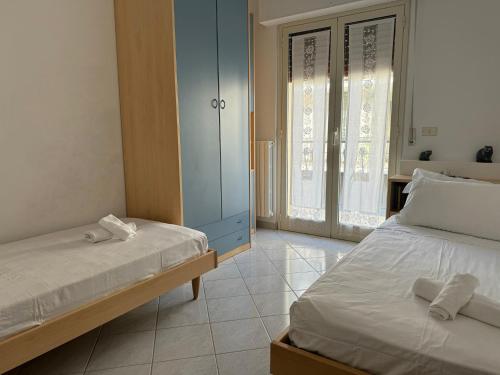 a bedroom with two beds and a blue cabinet at Homiday - Villino Caroli in Pineto