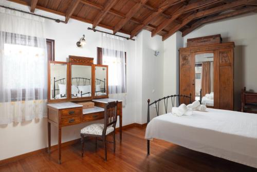 a bedroom with a bed and a desk and a mirror at Kalimera Archanes Village in Archanes