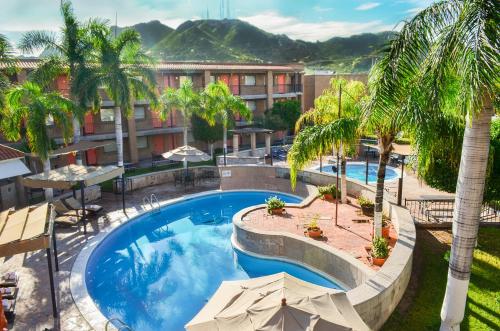 - une vue sur la piscine bordée de palmiers dans l'établissement Hotel Colonial Hermosillo, à Hermosillo