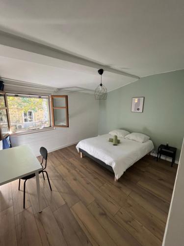 une chambre avec un lit, une table et une fenêtre dans l'établissement Charmante maison de ville, à Tarascon