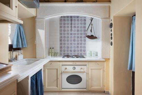 a kitchen with a sink and a washing machine at Kalimera Archanes Village in Archanes