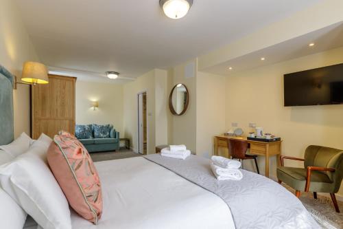 a hotel room with a white bed and a desk at Swan Revived Hotel in Milton Keynes