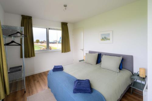 um quarto com uma cama grande e um sofá azul em Aan de Amstel em De Kwakel