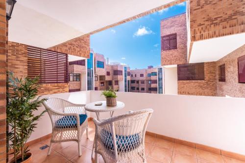 an apartment balcony with a table and chairs at VILOS LAS CANTERAS in Las Palmas de Gran Canaria