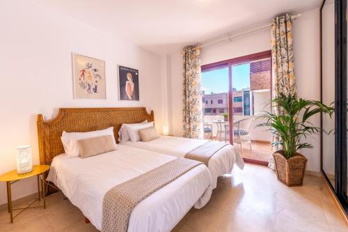 a bedroom with two beds and a large window at VILOS LAS CANTERAS in Las Palmas de Gran Canaria