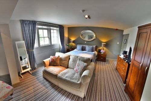 um quarto com uma cama e um sofá em White Lion em Hebden Bridge