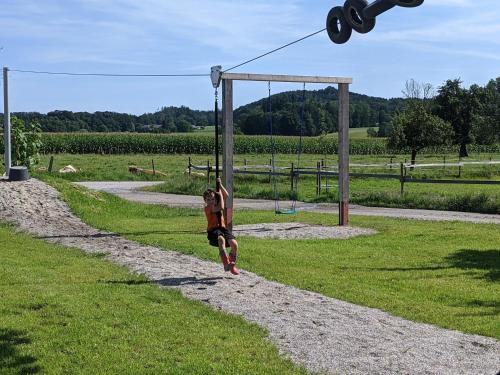 a young girl is playing on a swing at Niederauer Hof in Neubeuern
