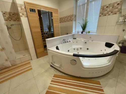 a large bathroom with a tub and a shower at Apartmán s privátnym wellnessom Exwell in Trenčín