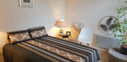 um quarto com uma cama com um candeeiro e uma planta em Appartement T2 à 10 min de Montpellier em Vendargues