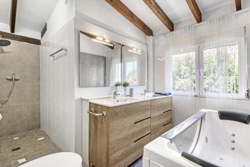 a bathroom with a tub and a sink and a toilet at Adriana in Denia