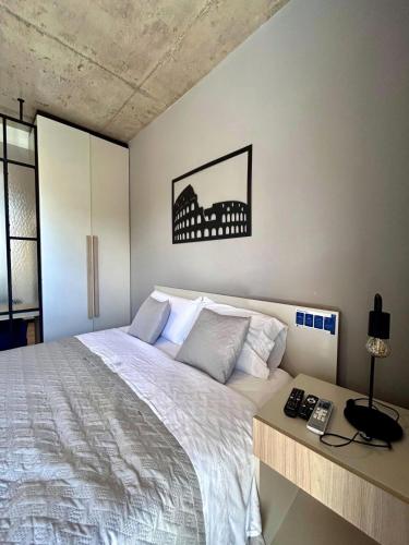 Un dormitorio con una cama y un escritorio con teléfono. en Usina Studio Salta, en Salta